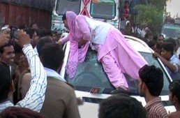 Indian woman climbs on top of a Mercedes SUV after security guard winks at her
