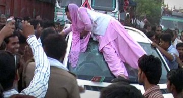 Indian woman climbs on top of a Mercedes SUV after security guard winks at her