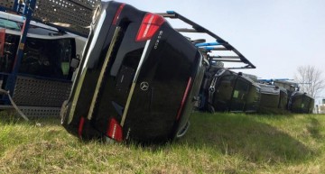 Truck full of Mercedes-Benz cars rolls over